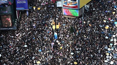 Crowds protesting for democracy in Hong Kong on a busy street.