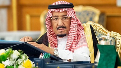 King Salman of Saudi Arabia seated at a desk during an official event.