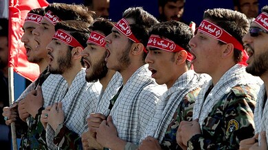 Group of protesters wearing headbands supporting Hezbollah and IRGC.