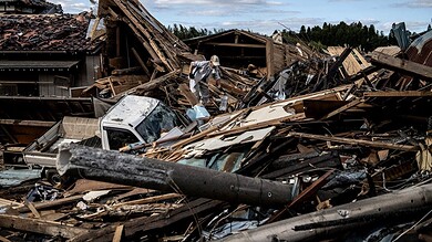 Scene of destruction caused by Typhoon Hagibis with debris and damaged buildings in Japan.