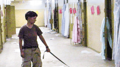 صورة حصلت عليها صحيفة واشنطن بوست ونشرت يوم 6 مايو، 2004، تظهر جندية من الجيش الأمريكي. ليندي إنغلاند، 21 عاماً، من السرية 372 للشرطة العسكرية مع معتقل عارٍ في سجن أبو غريب