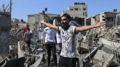 أشخاص يبحثون عن ناجين بعد غارة جوية إسرائيلية على رفح جنوب قطاع غزة