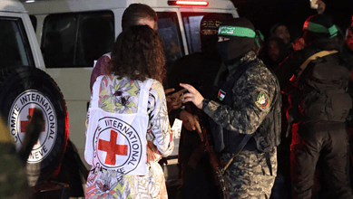 مقاتلو حماس والجهاد الإسلامي يتحدثون مع أعضاء الصليب الأحمر أثناء إطلاق سراح الرهائن في رفح، جنوب قطاع غزة، في 28 نوفمبر 2023.