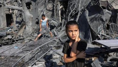 طفلة تقف بجوار بيوت دمرتها إسرائيل