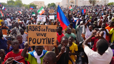 Nigeriens participate in a march called by supporters of coup leader Gen. Abdourahmane Tchiani in Niamey, Niger, Sunday, July 30, 2023. The sign reads: "Down with France, long live Putin