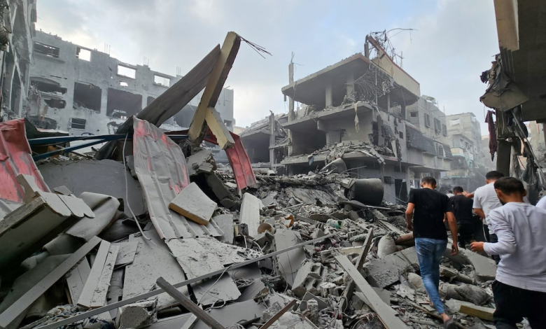 Palestinians gather at the site of Israeli strikes on houses, as the conflict between Israel and Palestinian Islamist group Hamas continues, in the northern Gaza Strip October 23, 2023.