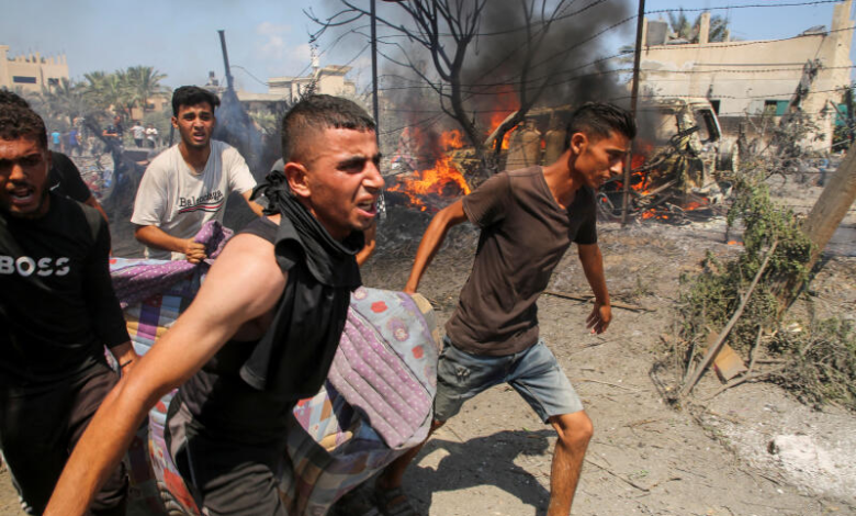 Palestinians carry a victim of an Israeli raid on a camp in the Al-Mawasi area in Khan Yunis, south of the Gaza Strip. July 13, 2024