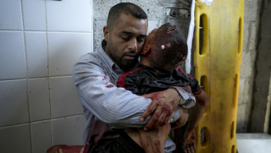 A Palestinian man holds the body of his child killed in the Israeli bombardment of the Gaza Strip, at a hospital morgue in Deir al-Balah, Tuesday, July 9, 2024.