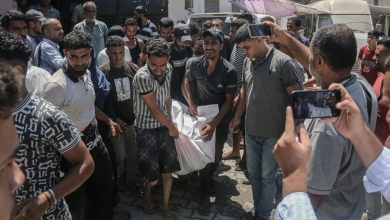 Palestinians carry the body of a victim near Al-Aqsa Martyrs Hospital following an Israeli airstrike on Deir al-Balah in the Gaza Strip, August 20, 2024