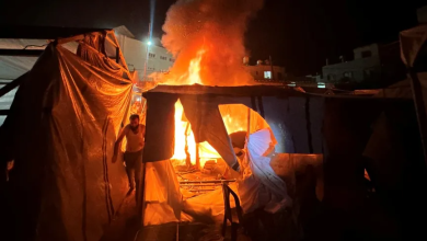 Palestinians extinguish a fire in a camp for displaced people after Israeli shelling in Deir al-Balah, central Gaza Strip, August 4, 2024