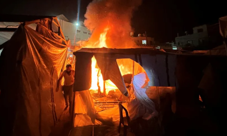 Palestinians extinguish a fire in a camp for displaced people after Israeli shelling in Deir al-Balah, central Gaza Strip, August 4, 2024