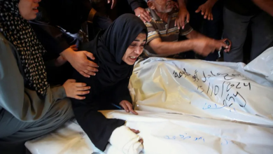 Palestinians stand next to the bodies of their relatives killed by Israel in the Gaza Strip, October 15, 2024.