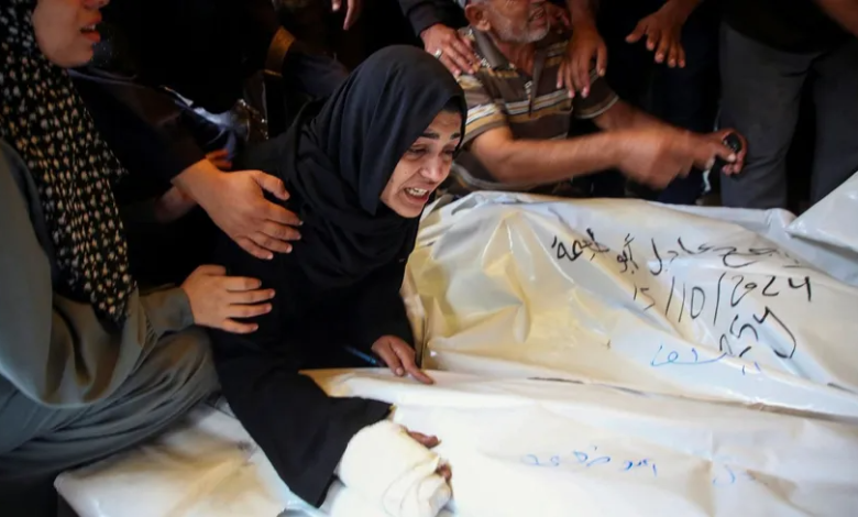 Palestinians stand next to the bodies of their relatives killed by Israel in the Gaza Strip, October 15, 2024.