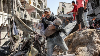 فلسطيني يحمل طفله المصاب في قصف إسرائيلي شمال قطاع غزة