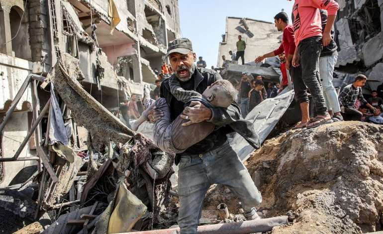 فلسطيني يحمل طفله المصاب في قصف إسرائيلي شمال قطاع غزة