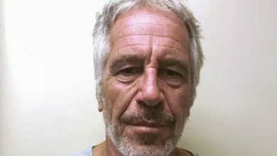 Man with gray hair and beard, looking directly at the camera, neutral expression.